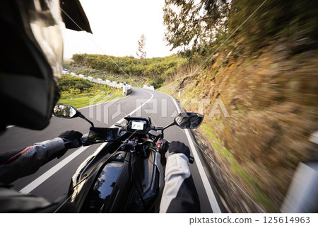 POV Shot of a Man Riding on a Touring Motorcycle. Hands of Motorcyclist on a Handlebars. 125614963