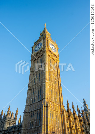 Big Ben rises majestically against a clear blue sky in London. This famous clock tower, part of the Palace of Westminster, showcases stunning architecture and rich history. 125615148