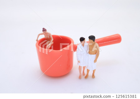 Miniature Scene with Figures Posing Near Oversized Red Measuring Miniature Scene with Figures Posing Near Oversized Red Measuring 125615381