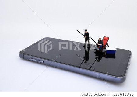 Fisherman on Smartphone Reflecting Creativity and Modern Fisherman on Smartphone Reflecting Creativity and Modern 125615386