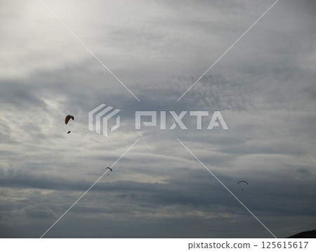Paragliders soaring gracefully through the sky at Daikanbo in Aso, Kumamoto Prefecture 125615617