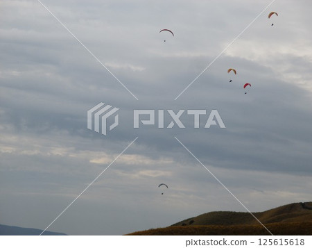 Paragliders soaring gracefully through the sky at Daikanbo in Aso, Kumamoto Prefecture 125615618