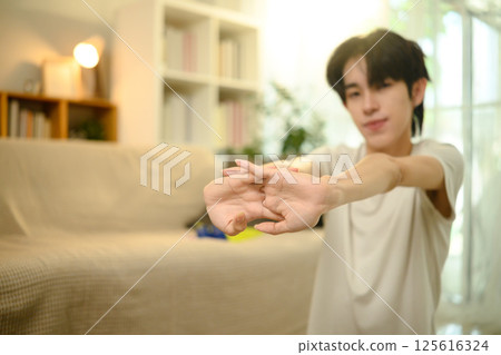 Young man stretching his arms before start morning workout 125616324