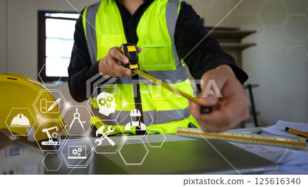 Construction worker using measuring tape with digital innovation and smart industry technology 125616340