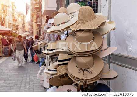 Sun hats in city street capture mood of summer season, season of warmth reflected in woven tones, season-inspired scene fits lifestyle visuals and travel storytelling Sun hats in city street capture mood of summer season, season of warmth reflected in woven tones, season-inspired scene fits lifestyle visuals and travel storytelling 125616376