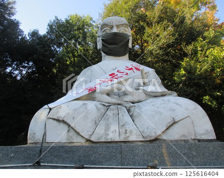 A large statue of Musashi, who spent his later years in Kumamoto, meditates while wearing a mask amid the coronavirus pandemic in Matsuo-cho, Nishi-ku, Kumamoto. 125616404