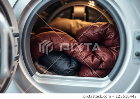 Winter jackets in front-loading washing machine before wash 125616442