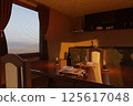 Glasses, candles on a wooden table in a cozy kitchen, filled with warm evening light 125617048