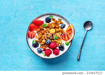 Granola with yogurt and fresh fruit. Organic gourmet muesli, overhead Granola with yogurt and fresh fruit. Organic gourmet muesli, overhead 125617517