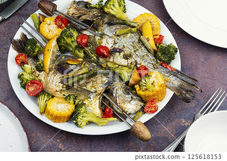 Baked dorado fish with asparagus and vegetables. Baked dorado fish with asparagus and vegetables. 125618153