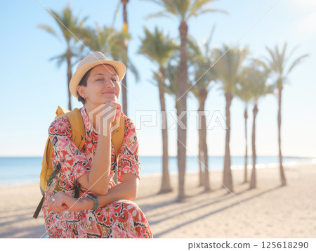 Woman in dress strolls through colorful streets of Spanish coastal town of La Vila Joiosa or Villajoyosa. sunny winter atmosphere highlights charm of Mediterranean architecture and quiet seaside life Woman in dress strolls through colorful streets of Spanish coastal town of La Vila Joiosa or Villajoyosa. sunny winter atmosphere highlights charm of Mediterranean architecture and quiet seaside life 125618290