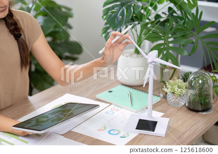ESG sustainability evaluation with tablet and wind turbine in focus ESG sustainability evaluation with tablet and wind turbine in focus 125618600