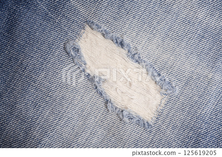 Closeup detail of torn on blue jeans. Denim jeans texture. Closeup detail of torn on blue jeans. Denim jeans texture. 125619205
