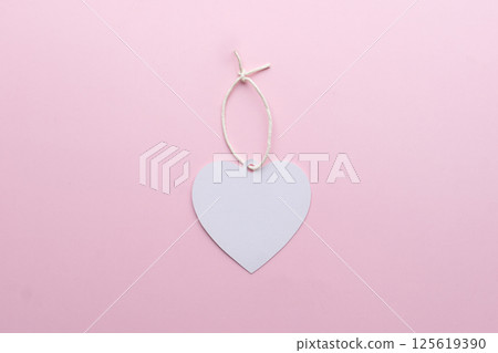 Blank tag label in heart shape with string on pink background. Mock up for design. Blank tag label in heart shape with string on pink background. Mock up for design. 125619390