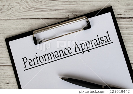 Clipboard with a document titled Performance Appraisal text, placed on a white wooden surfac Clipboard with a document titled Performance Appraisal text, placed on a white wooden surfac 125619442