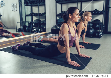 Pretty young women doing yoga and looking relaxed and peaceful 125619611