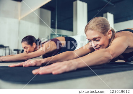 Pretty young women doing yoga and looking relaxed and peaceful 125619612