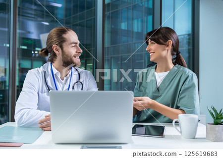 Female practitioner working with msn doctor in clinic using computer to analyze patient data Female practitioner working with msn doctor in clinic using computer to analyze patient data 125619683