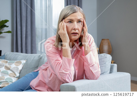 Mid aged woman suffering from a headache and looking exhausted 125619717