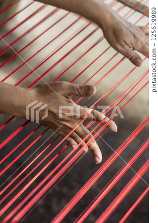 worker hands deyail with traditional natural silk making machine strings 125619989