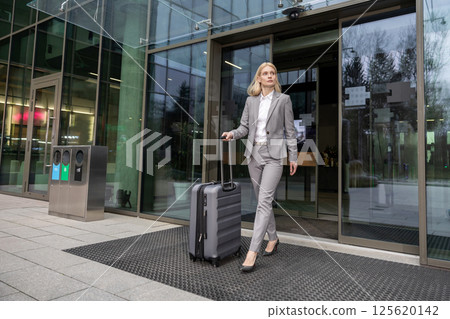 Female traveler arriving at airport with luggage for professional business journey Female traveler arriving at airport with luggage for professional business journey 125620142