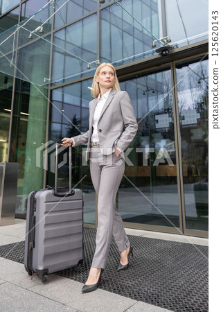 Professional woman traveling with luggage ready for business trip Professional woman traveling with luggage ready for business trip 125620143