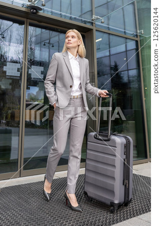 Businesswoman with suitcase heading from departure after corporate flight Businesswoman with suitcase heading from departure after corporate flight 125620144