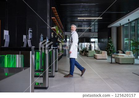 Male doctor going to the security entrance while coming to his working place 125620157
