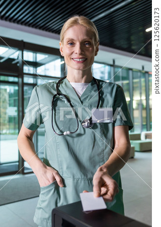Female blonde doctor passing through security by using access card 125620173