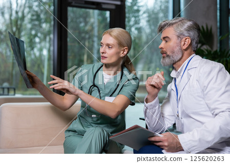 Two colleagues discussing xray results and looking involved 125620263