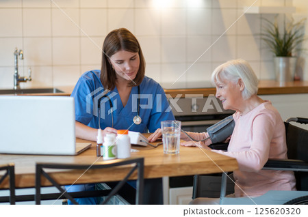 Female doctor helping senior patient with blood pressure test and pulse measurement Female doctor helping senior patient with blood pressure test and pulse measurement 125620320