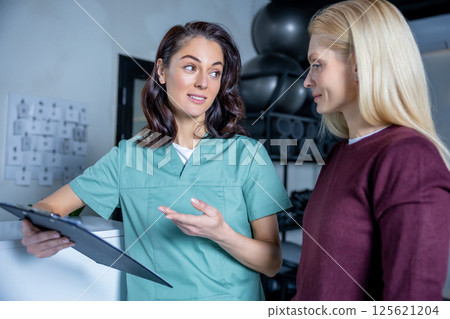 Female doctor explaining to the patient diagnostics results Female doctor explaining to the patient diagnostics results 125621204