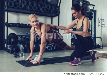 Young female coach training a young woman in the gym 125621357