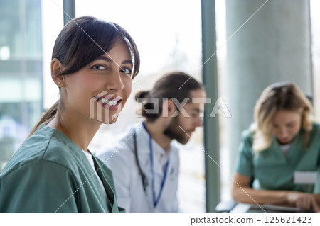 Female doctor in hospital discussing treatment plans with healthcare team Female doctor in hospital discussing treatment plans with healthcare team 125621423