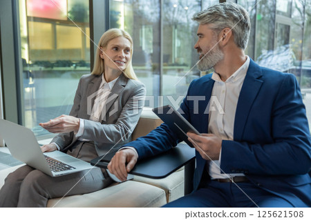 Executive and entrepreneur speaking together about business strategy with laptop and tablet Executive and entrepreneur speaking together about business strategy with laptop and tablet 125621508