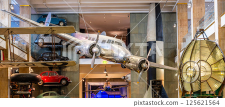 The Lockheed 10a Electra hangs prominently at London's Science Museum, showcasing aviation history amidst various vintage vehicles, creating a captivating visual experience for visitors. 125621564