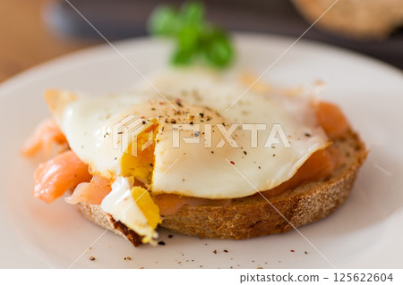 Diet breakfast with cooked egg and lightly salted red fish 125622604