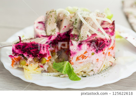 layered vegetable salad with beets and herring, on a wooden table 125622618