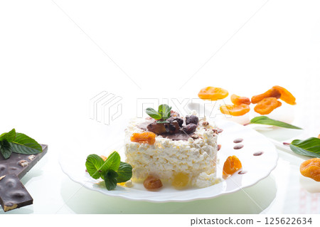 sweet cottage cheese breakfast in a plate with chocolate syrup with candied fruits sweet cottage cheese breakfast in a plate with chocolate syrup with candied fruits 125622634