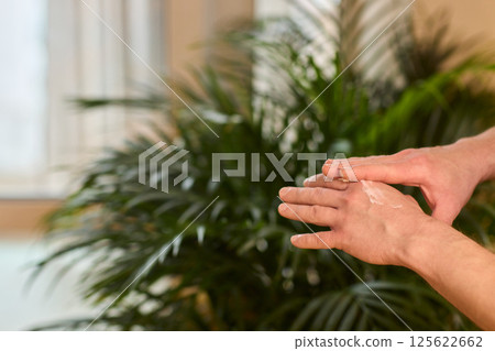 A gloved hand prepares to perform a care procedure safely and professionally in healthcare A gloved hand prepares to perform a care procedure safely and professionally in healthcare 125622662