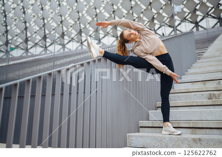 Strong woman doing exercises outdoors in the morning. Active life, healthy lifestyle. Strong woman doing exercises outdoors in the morning. Active life, healthy lifestyle. 125622762