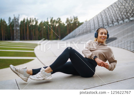 Strong woman doing exercises outdoors in the morning. Active life, healthy lifestyle. Strong woman doing exercises outdoors in the morning. Active life, healthy lifestyle. 125622767