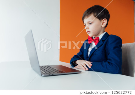 Boy in school uniform working on laptop 125622772