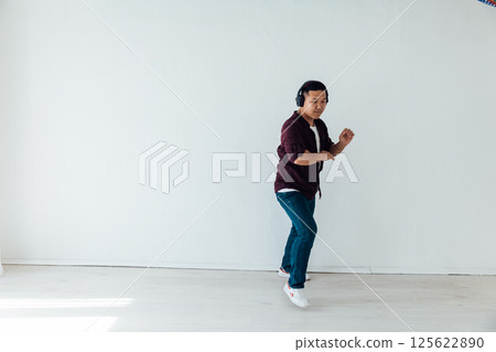 Man in headphones listening to music dancing 125622890