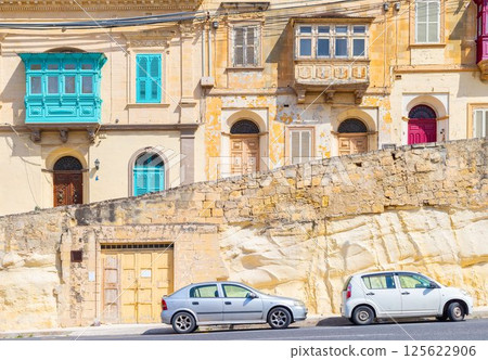 View of a typical maltese street with houses in traditional architecture style View of a typical maltese street with houses in traditional architecture style 125622906