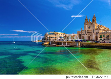 Picturesque view of the Knisja tal-Karmnu and turquise-green water in St. Julian's Bay in Sliema, Malta 125622944