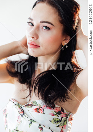 Portrait of a beautiful brunette woman in a dress with flowers Portrait of a beautiful brunette woman in a dress with flowers 125622968