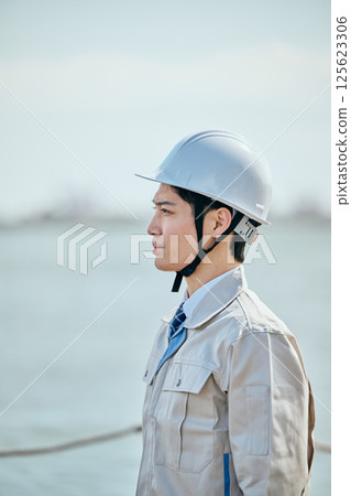 A young man in his 20s wearing work clothes gazing into the distance A young man in his 20s wearing work clothes gazing into the distance 125623306