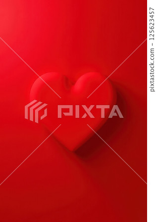 Vibrant red heart with shadow on red background 125623457