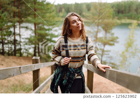 Attractive young woman enjoying fresh air on the lake. Travel, Hiking, nature Attractive young woman enjoying fresh air on the lake. Travel, Hiking, nature 125623902